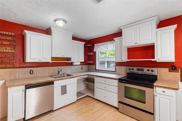 1104 W Marjorie St, Lakeland, FL 33815 - kitchen featuring stainless steel appliances, open shelves, a textured ceiling, decorative backsplash, and light wood finished floors