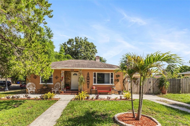 1104 W Marjorie St, Lakeland, FL 33815 - view of front of house with stucco siding, a porch, and a chimney