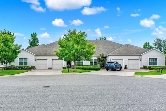 3210 Sonesta Ct Unit B, Clermont, FL 34711 - view of front of home featuring an attached garage, stucco siding, concrete driveway, and roof with shingles