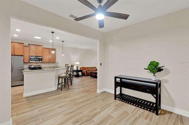 3210 Sonesta Ct Unit B, Clermont, FL 34711 - kitchen with stainless steel appliances, light countertops, backsplash, ceiling fan, and light wood-style floors