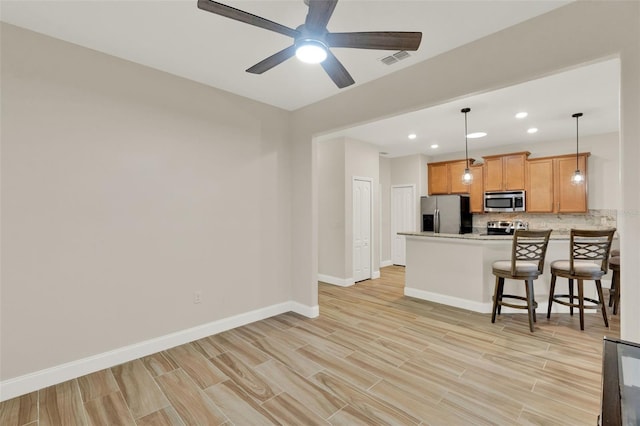 3210 Sonesta Ct Unit B, Clermont, FL 34711 - kitchen with appliances with stainless steel finishes, backsplash, a peninsula, light wood-style floors, and recessed lighting