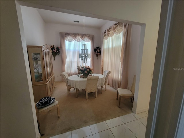 8603 Snowfire Dr, Orlando, FL 32818 - dining area with light colored carpet, light tile patterned floors, and a chandelier