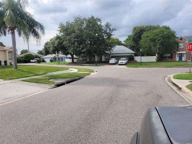 8603 Snowfire Dr, Orlando, FL 32818 - view of asphalt street featuring a residential view, traffic signs, curbs, and sidewalks