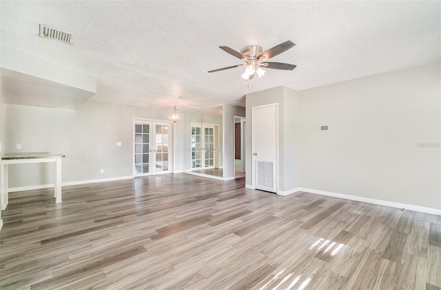 1422 Russell Ave, Orlando, FL 32806 - unfurnished living room with a textured ceiling, a ceiling fan, french doors, wood finished floors, and a chandelier