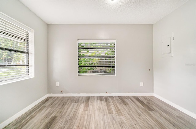 1422 Russell Ave, Orlando, FL 32806 - spare room featuring electric panel, light wood-type flooring, and a textured ceiling