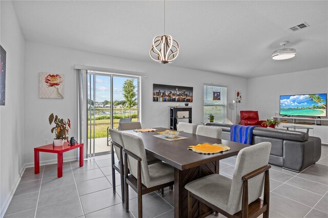 873 Daring Dr, Davenport, FL 33837 - dining room with light tile patterned floors, healthy amount of natural light, and a chandelier