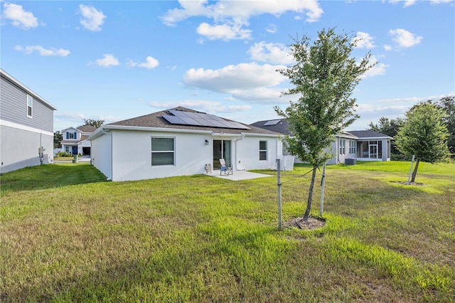 873 Daring Dr, Davenport, FL 33837 - back of house featuring a patio, solar panels, a lawn, and stucco siding