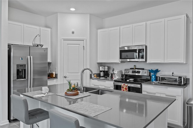 873 Daring Dr, Davenport, FL 33837 - kitchen featuring stainless steel appliances, a center island with sink, a kitchen bar, white cabinets, and recessed lighting