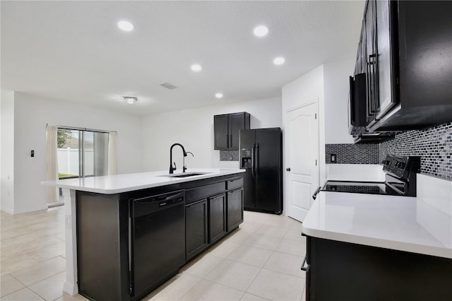 1565 Diamond Loop Dr, Kissimmee, FL 34744 - kitchen featuring black appliances, light countertops, decorative backsplash, a center island with sink, and recessed lighting