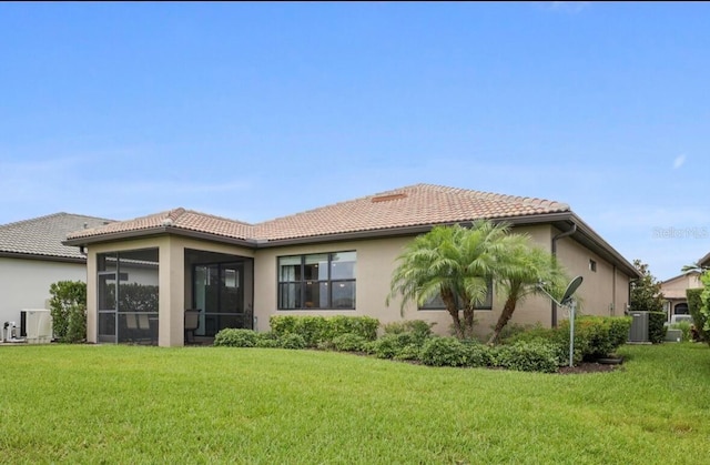 13084 Rinella St, Venice, FL 34293 - back of property with a tile roof, stucco siding, a lawn, and a sunroom