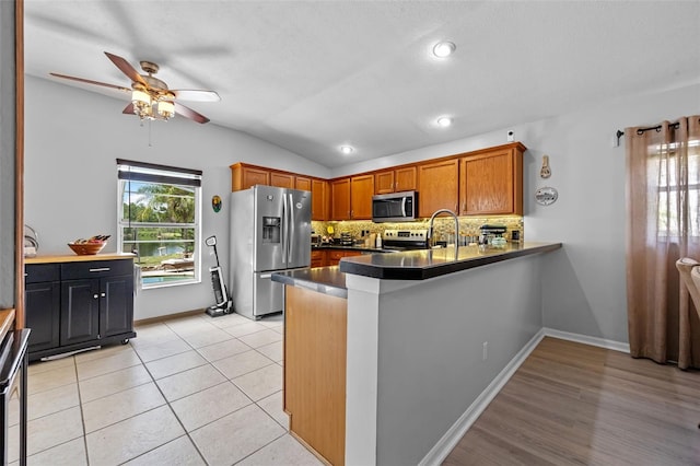 14566 Quail Trail Cir, Orlando, FL 32837 - kitchen with stainless steel appliances, ceiling fan, decorative backsplash, dark countertops, and lofted ceiling