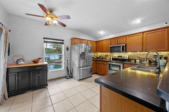 14566 Quail Trail Cir, Orlando, FL 32837 - kitchen with stainless steel appliances, lofted ceiling, a ceiling fan, decorative backsplash, and dark countertops