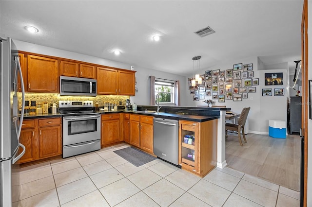 14566 Quail Trail Cir, Orlando, FL 32837 - kitchen with appliances with stainless steel finishes, brown cabinets, dark countertops, decorative backsplash, and recessed lighting