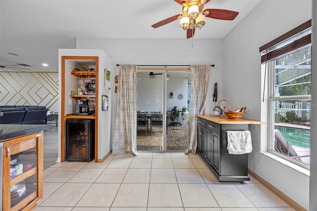 14566 Quail Trail Cir, Orlando, FL 32837 - kitchen with wine cooler, a ceiling fan, dark cabinets, and light tile patterned floors