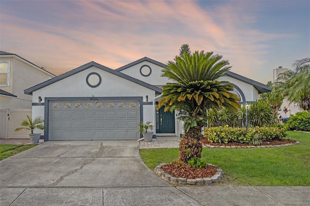 14566 Quail Trail Cir, Orlando, FL 32837 - view of front of house featuring concrete driveway, stucco siding, a garage, and a lawn