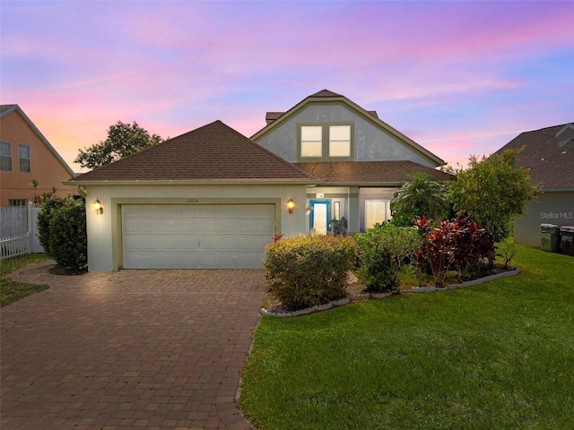 2076 Shannon Lakes Blvd, Kissimmee, FL 34743 - traditional-style house with decorative driveway, stucco siding, and a garage