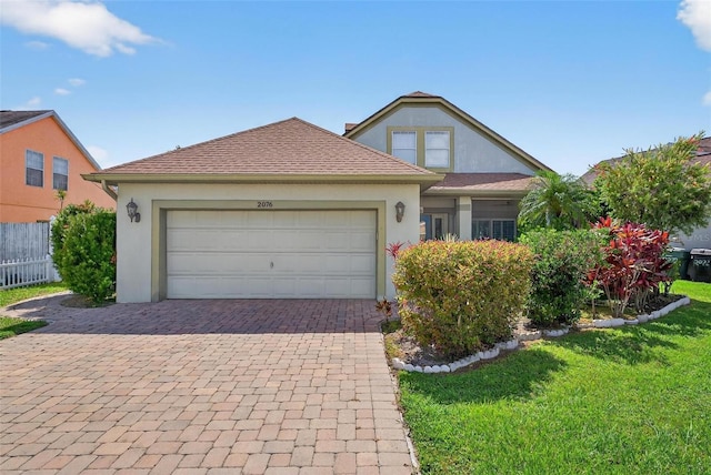 2076 Shannon Lakes Blvd, Kissimmee, FL 34743 - traditional-style home with stucco siding, decorative driveway, and an attached garage