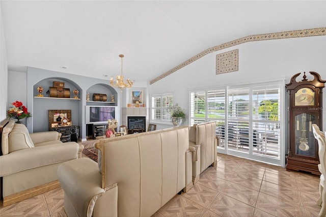 2076 Shannon Lakes Blvd, Kissimmee, FL 34743 - living room featuring a chandelier, a glass covered fireplace, built in shelves, and high vaulted ceiling