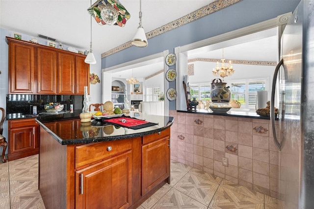 2076 Shannon Lakes Blvd, Kissimmee, FL 34743 - kitchen with freestanding refrigerator, a chandelier, a center island, decorative light fixtures, and brown cabinetry