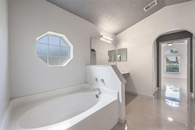 10675 Fairhaven Way, Orlando, FL 32825 - full bathroom with a textured ceiling, a garden tub, and vanity