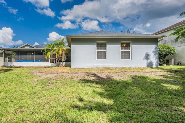 10675 Fairhaven Way, Orlando, FL 32825 - rear view of house featuring a sunroom, stucco siding, and a yard