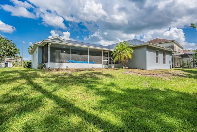 10675 Fairhaven Way, Orlando, FL 32825 - back of house featuring a sunroom, a lawn, and stucco siding