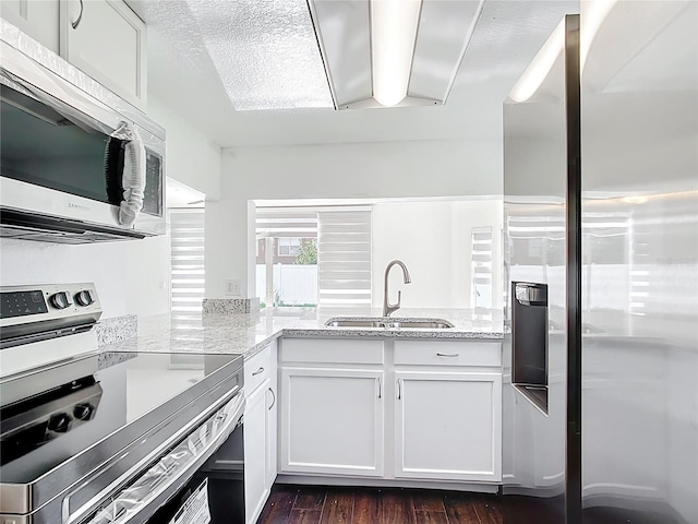 709 Orchid Dr, Davenport, FL 33897 - kitchen featuring appliances with stainless steel finishes, light stone countertops, white cabinetry, and dark wood-type flooring