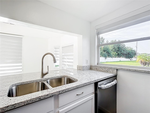 709 Orchid Dr, Davenport, FL 33897 - kitchen featuring dishwasher, light stone countertops, and white cabinetry