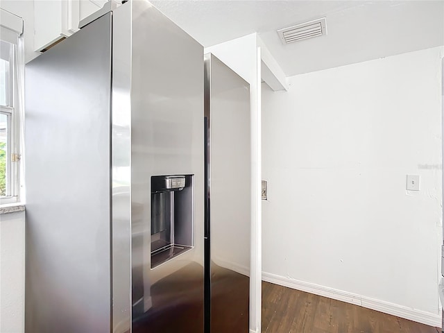 709 Orchid Dr, Davenport, FL 33897 - kitchen view of stainless steel fridge with ice dispenser, white cabinetry, and dark wood-type flooring
