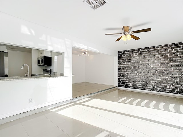 709 Orchid Dr, Davenport, FL 33897 - tiled empty room featuring brick wall and ceiling fan