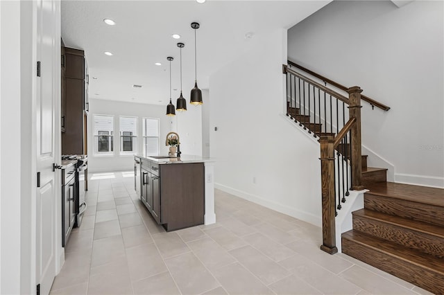 2018 Packing District Way, Orlando, FL 32804 - kitchen featuring recessed lighting, dark brown cabinets, gas range, an island with sink, and pendant lighting
