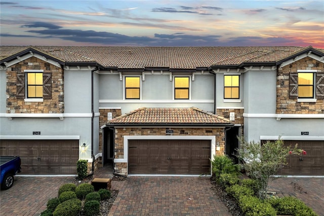 1246 Payne Stewart Dr, Davenport, FL 33896 - view of front of house with stone siding, a tile roof, and stucco siding