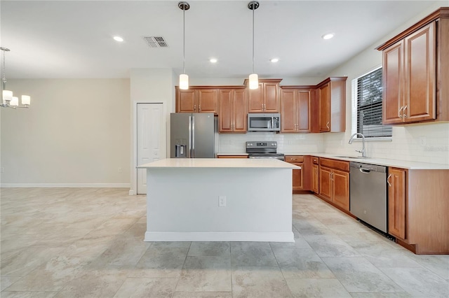 1246 Payne Stewart Dr, Davenport, FL 33896 - kitchen featuring stainless steel appliances, decorative backsplash, brown cabinetry, light countertops, and a center island