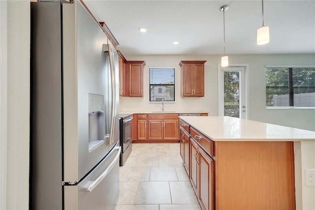 1246 Payne Stewart Dr, Davenport, FL 33896 - kitchen with appliances with stainless steel finishes, light countertops, plenty of natural light, a kitchen island, and recessed lighting
