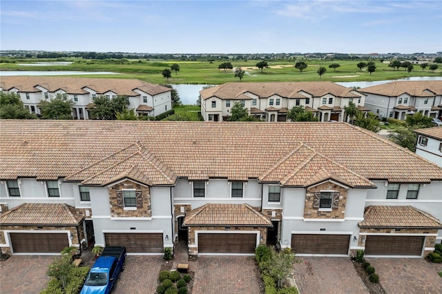1246 Payne Stewart Dr, Davenport, FL 33896 - view of front of house with stone siding, a tile roof, stucco siding, a water view, and golf course view