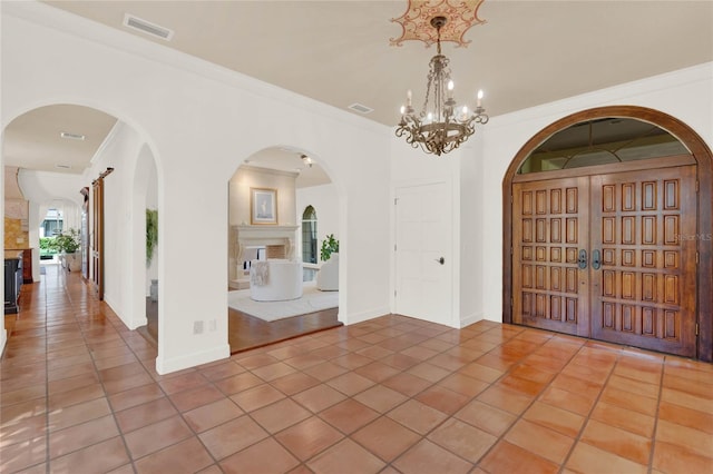 3130 Butler Bay Dr N, Windermere, FL 34786 - entrance foyer with light tile patterned floors, a chandelier, a fireplace, arched walkways, and ornamental molding