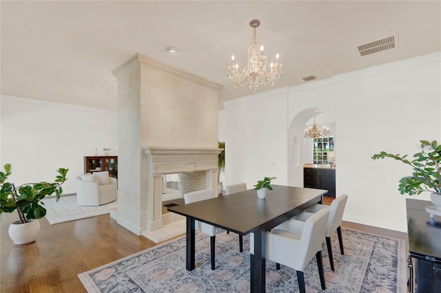 3130 Butler Bay Dr N, Windermere, FL 34786 - dining area featuring a chandelier, arched walkways, ornamental molding, wood finished floors, and a tile fireplace
