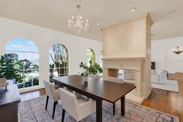 3130 Butler Bay Dr N, Windermere, FL 34786 - dining room featuring a chandelier, ornamental molding, light wood-style floors, a multi sided fireplace, and recessed lighting