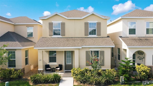 129 Boydfield Ln, Davenport, FL 33837 - view of front of home with roof with shingles, stucco siding, and covered porch