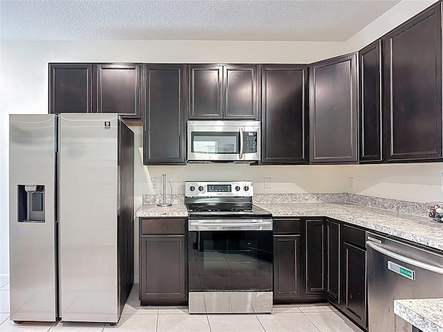 129 Boydfield Ln, Davenport, FL 33837 - kitchen featuring appliances with stainless steel finishes, light tile patterned floors, light countertops, and a textured ceiling