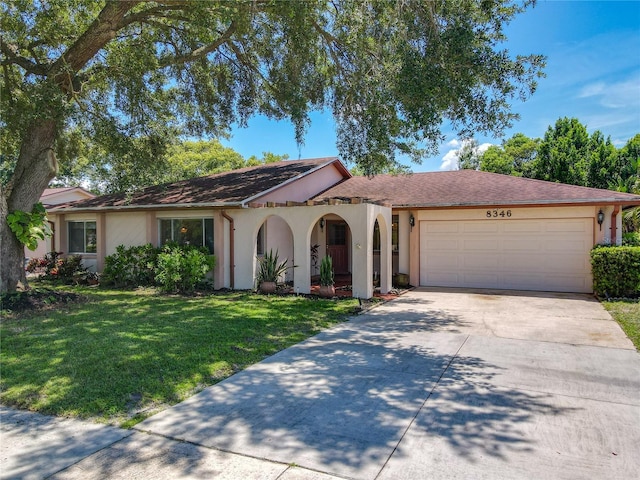 8346 Mattituck Cir, Orlando, FL 32829 - view of front of property with concrete driveway, stucco siding, a garage, and a front lawn