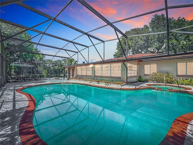 8346 Mattituck Cir, Orlando, FL 32829 - pool at dusk with a lanai, a pool with connected hot tub, and a patio area