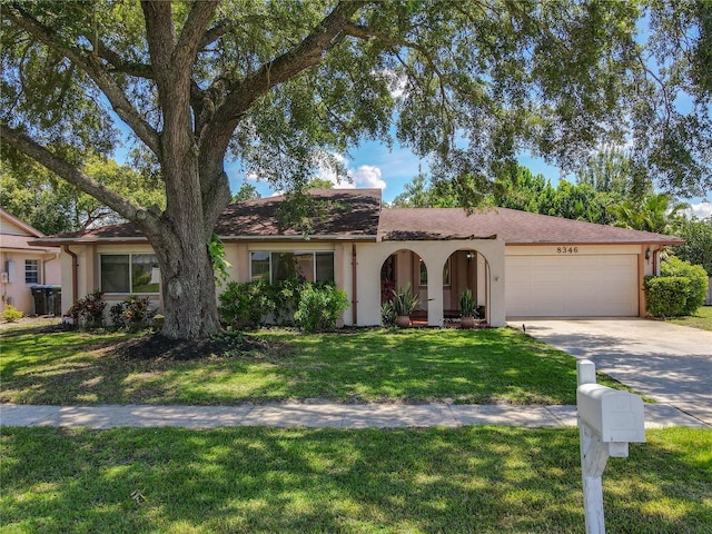8346 Mattituck Cir, Orlando, FL 32829 - view of front facade featuring an attached garage, stucco siding, driveway, and a front lawn
