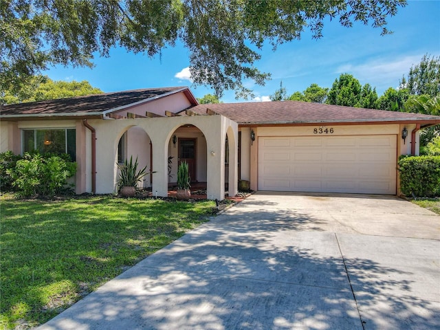 8346 Mattituck Cir, Orlando, FL 32829 - view of front of house featuring a garage, driveway, stucco siding, and a front yard