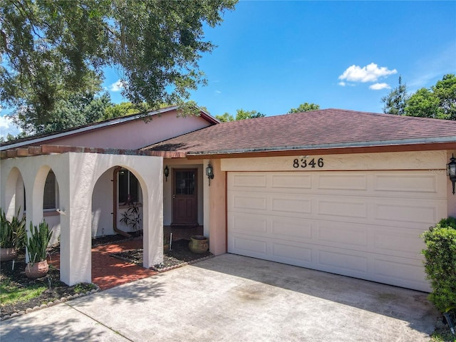 8346 Mattituck Cir, Orlando, FL 32829 - view of front of home featuring driveway, roof with shingles, a garage, and stucco siding