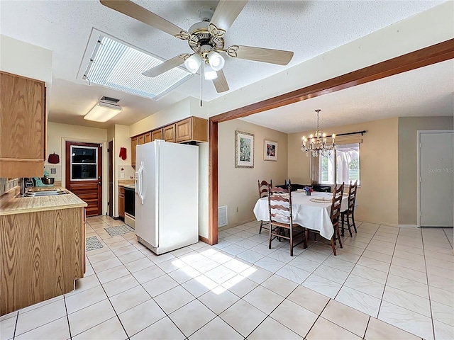 8346 Mattituck Cir, Orlando, FL 32829 - kitchen with white refrigerator with ice dispenser, light countertops, a chandelier, light tile patterned floors, and ceiling fan