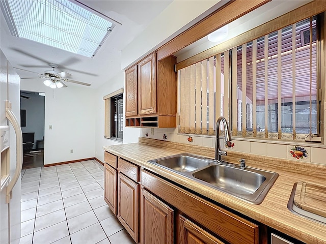 8346 Mattituck Cir, Orlando, FL 32829 - kitchen with light countertops, light tile patterned flooring, brown cabinets, and a ceiling fan