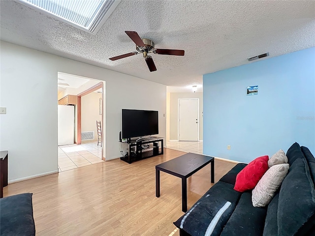 8346 Mattituck Cir, Orlando, FL 32829 - living area with ceiling fan, light wood finished floors, and a textured ceiling