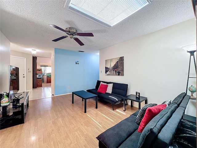 8346 Mattituck Cir, Orlando, FL 32829 - living area featuring a textured ceiling, light wood-type flooring, and a ceiling fan