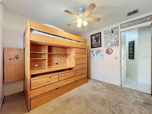 8346 Mattituck Cir, Orlando, FL 32829 - unfurnished bedroom with carpet, a textured ceiling, a ceiling fan, and tile patterned flooring